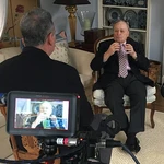 Bill Archer, seated, being filmed during an interview.