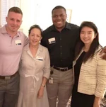Marylin Harris stands smiling with three other people.